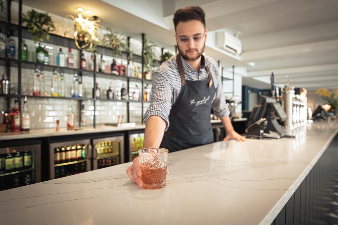 bartender serving drink on marble bar counter