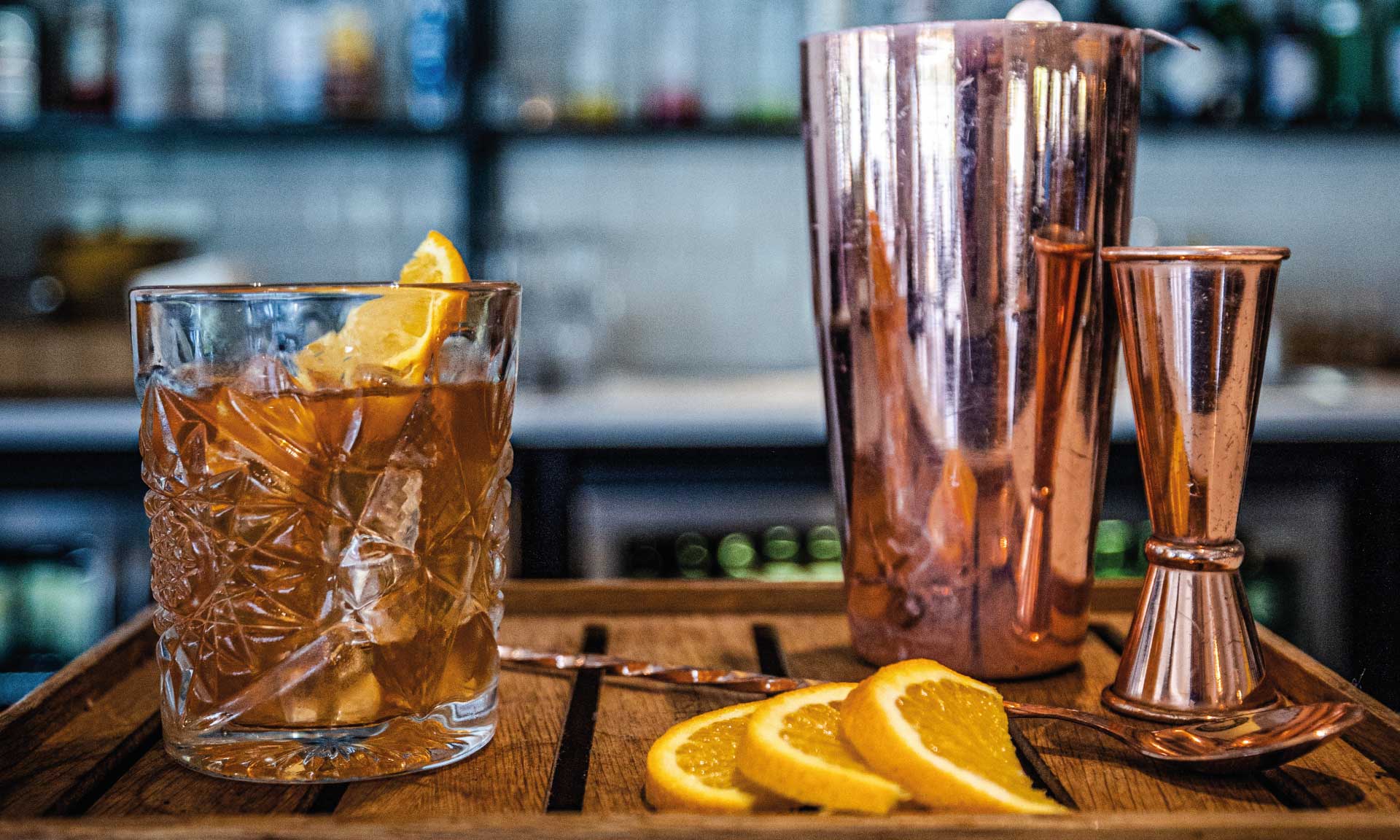 whiskey cocktail glass copper shaker orange slices wooden tray